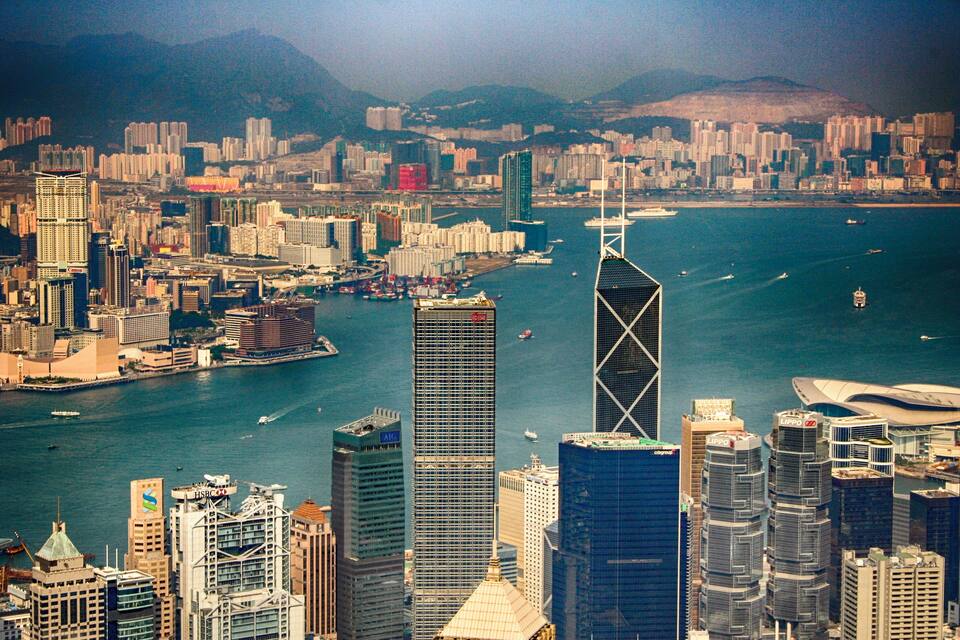 A cityscape with a prominent skyscraper, a body of water, and surrounding buildings.