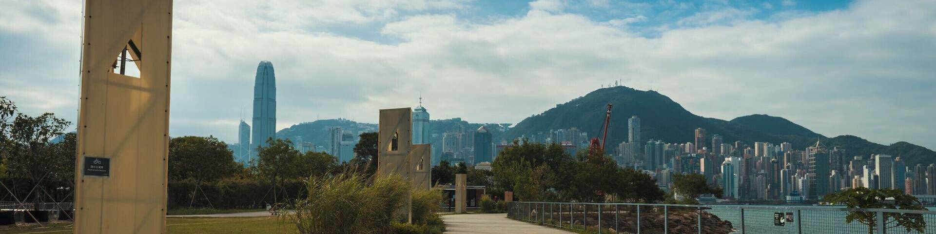 Un sendero que lleva a una ciudad con rascacielos modernos y una montaña al fondo.