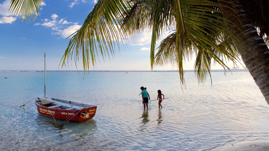 A calm sea with a small boat named "The Boat House" anchored near the shore.