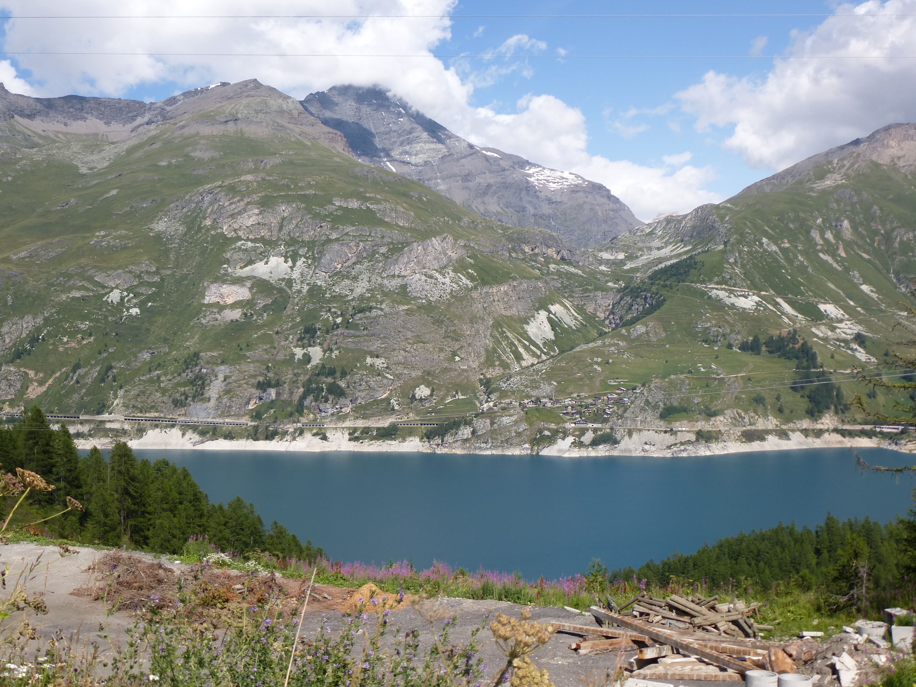 A mountainous landscape with a lake and a small settlement.