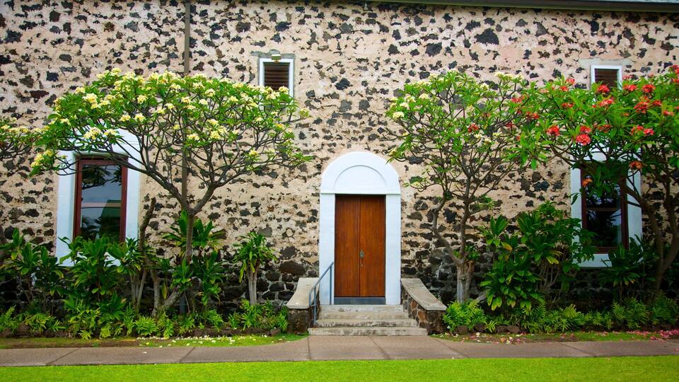 A building with a stone facade, a wooden door, and two windows.