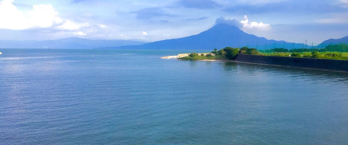 A calm river with a mountain in the background.