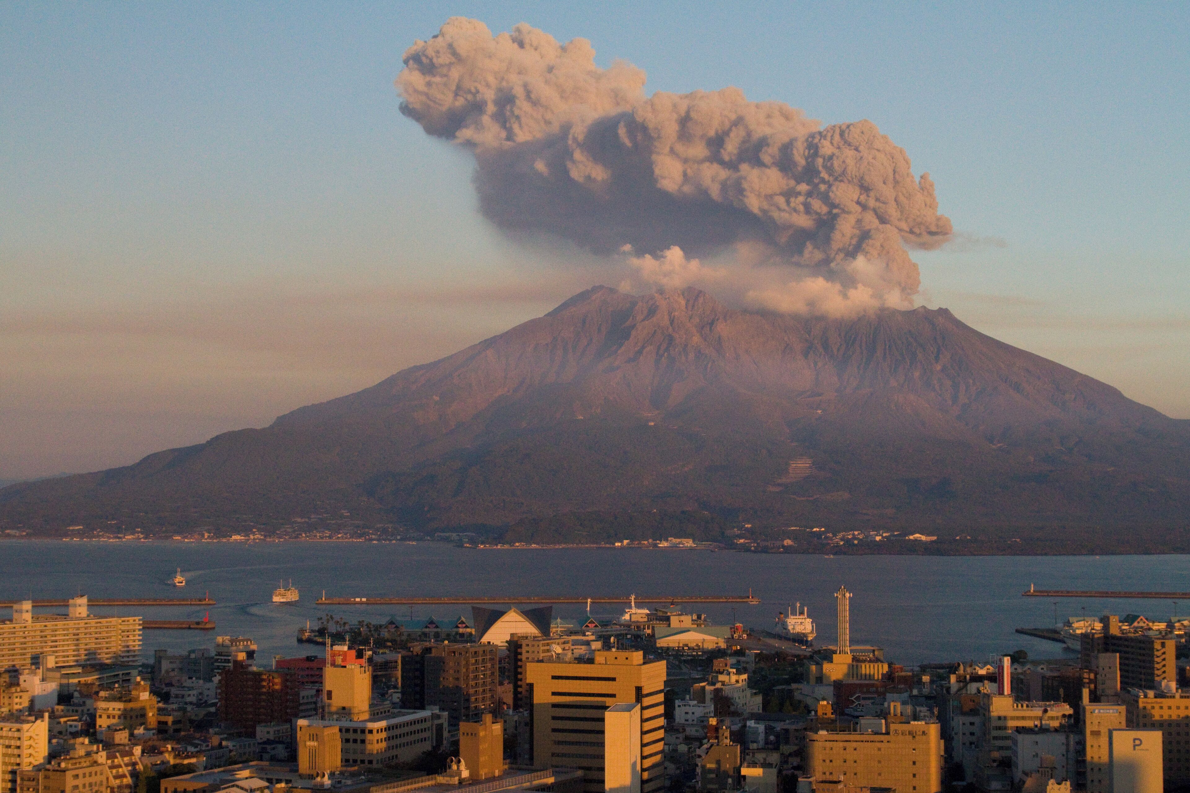 A cityscape with a volcano in the background.