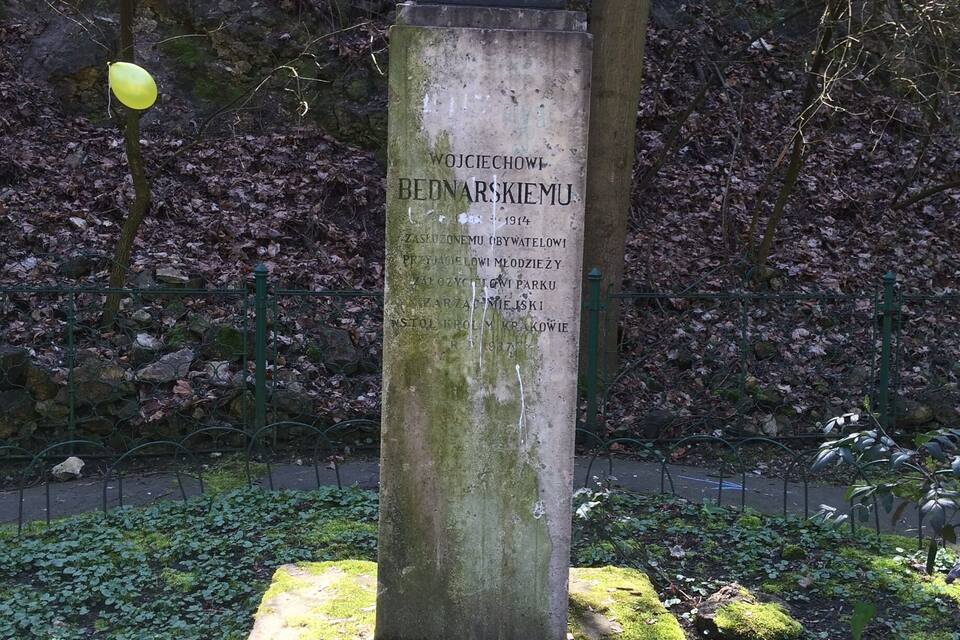 A statue with a plaque in a park.