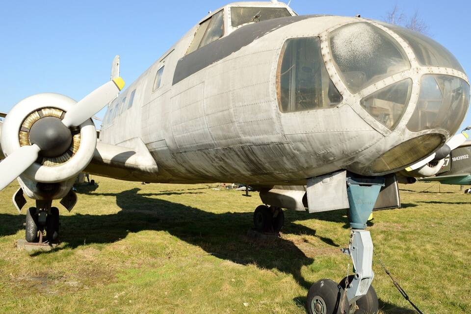Un avión militar antiguo con hélices, mostrando signos de desgaste y una cabina transparente.