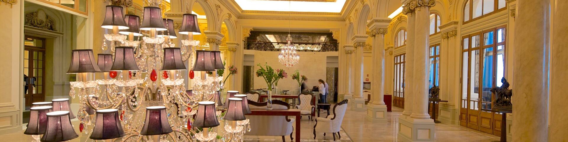 A grand lobby with ornate chandeliers, marble floors, and classical architecture.