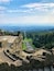 Ancient ruins with stone steps and a view of a city in the distance.