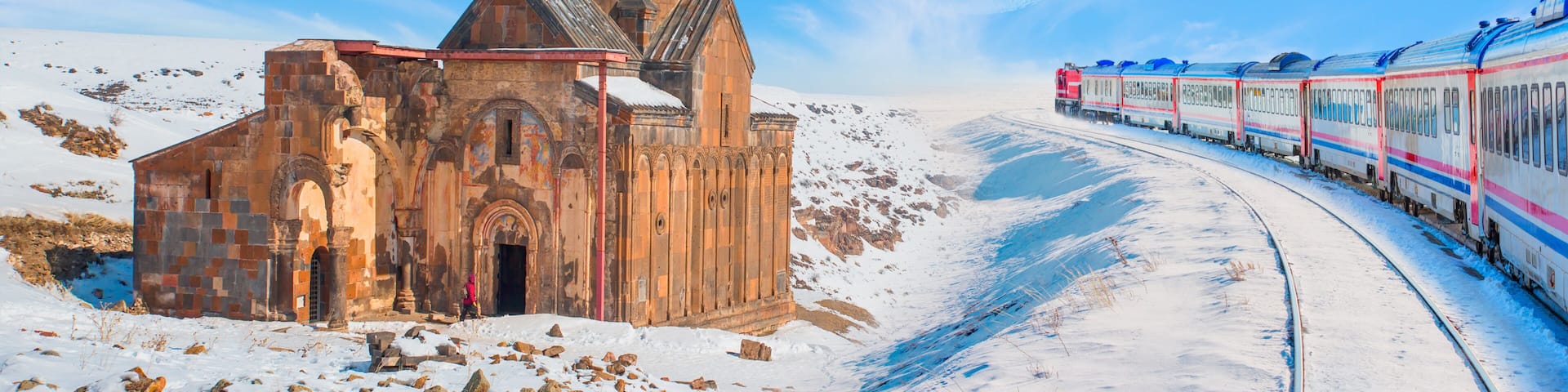 Red diesel train (East express) in motion at the snow covered railway platform - Ani Ruins, Ani is a ruined and uninhabited medieval Armenian city "Elements of this image furnished by NASA "