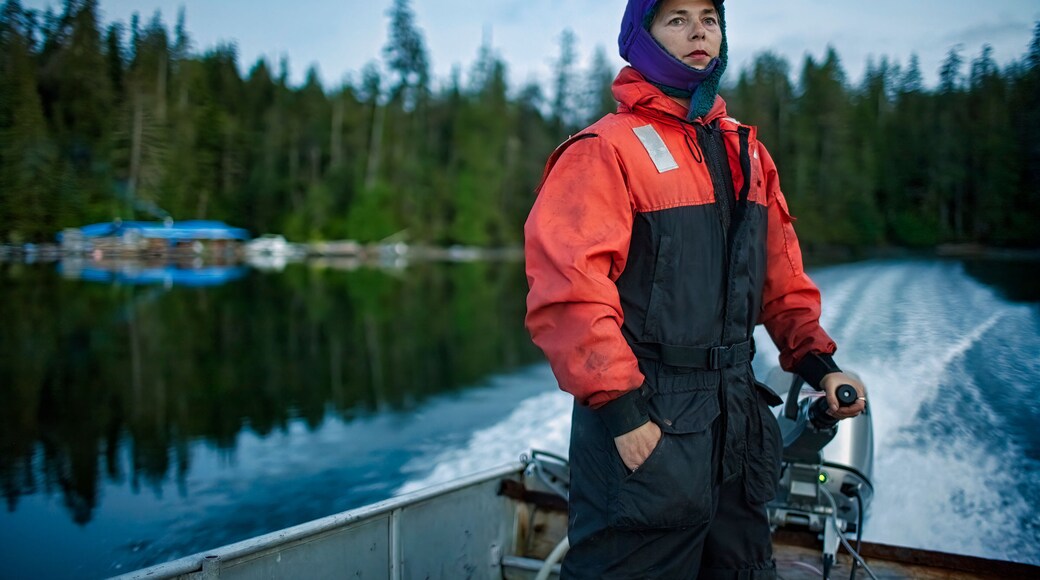 A woman drives a boat to Thorne Bay for supplies, Alaska, USA