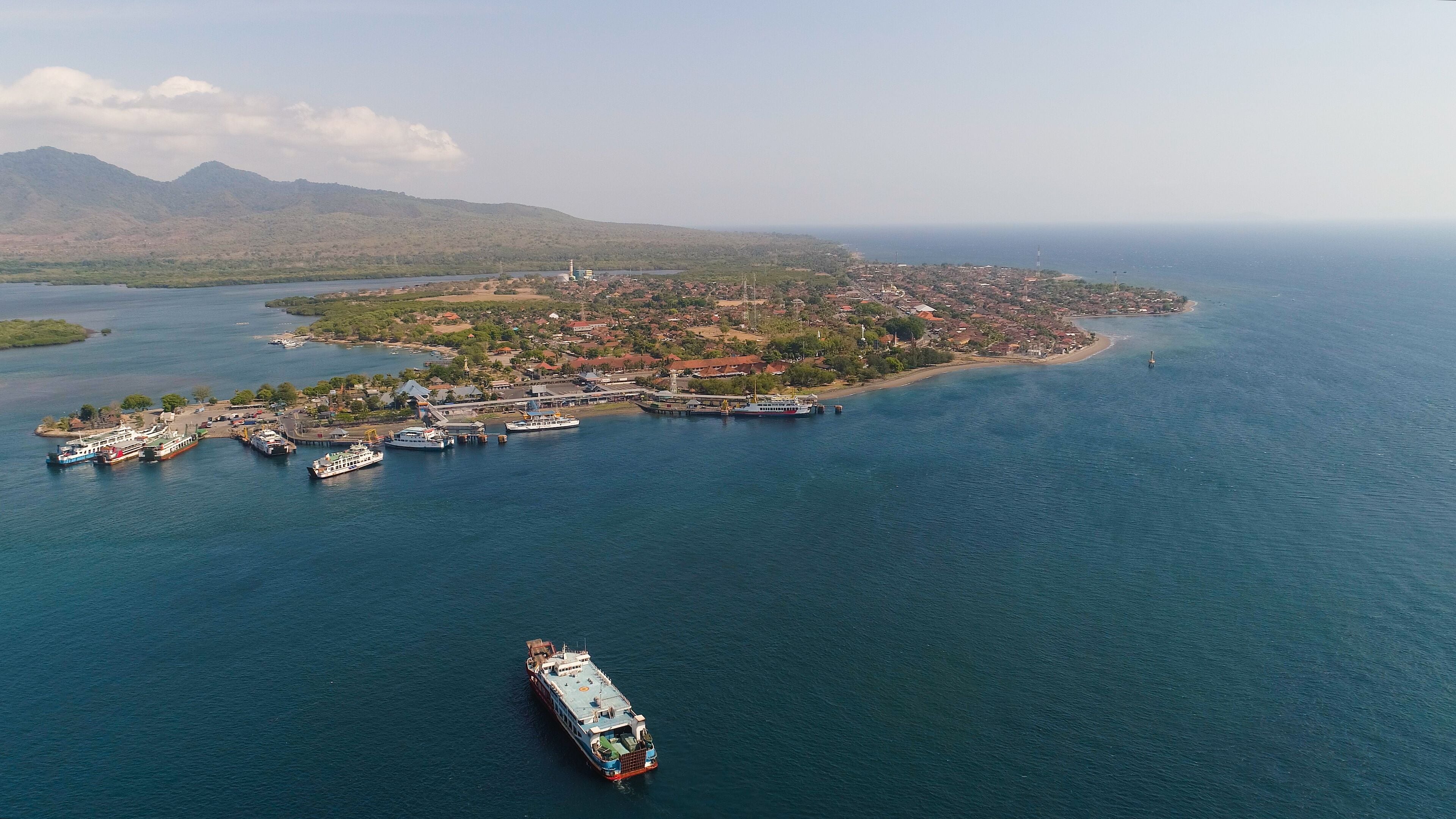 Aerial view ferry port gilimanuk with ferry boats, vehicles. Ferries transport vehicles and passengers in port. Port for departure from Bali to the island of Java.