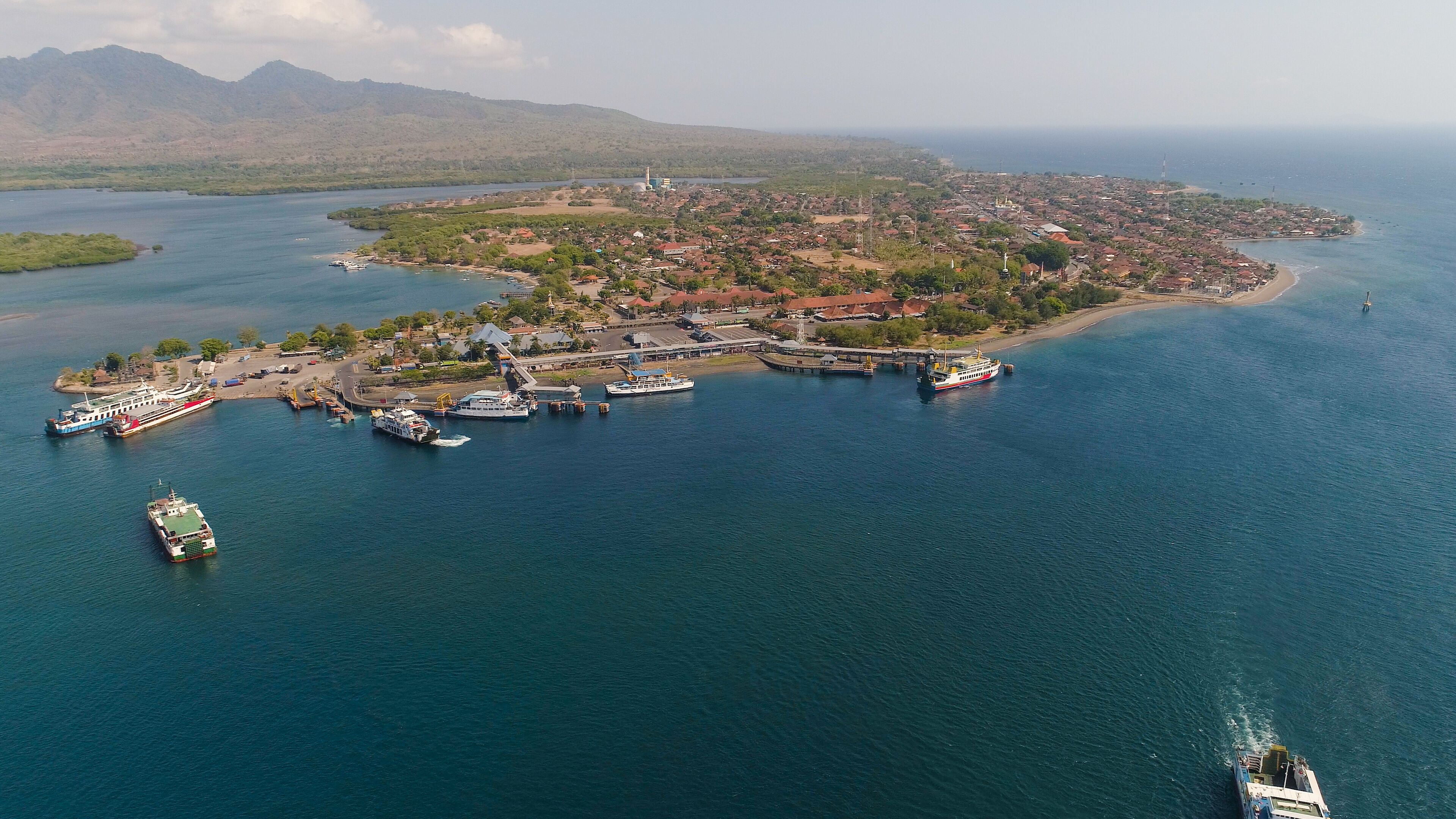 Aerial view ferry port gilimanuk with ferry boats, vehicles. Ferries transport vehicles and passengers in port. Port for departure from Bali to the island of Java.