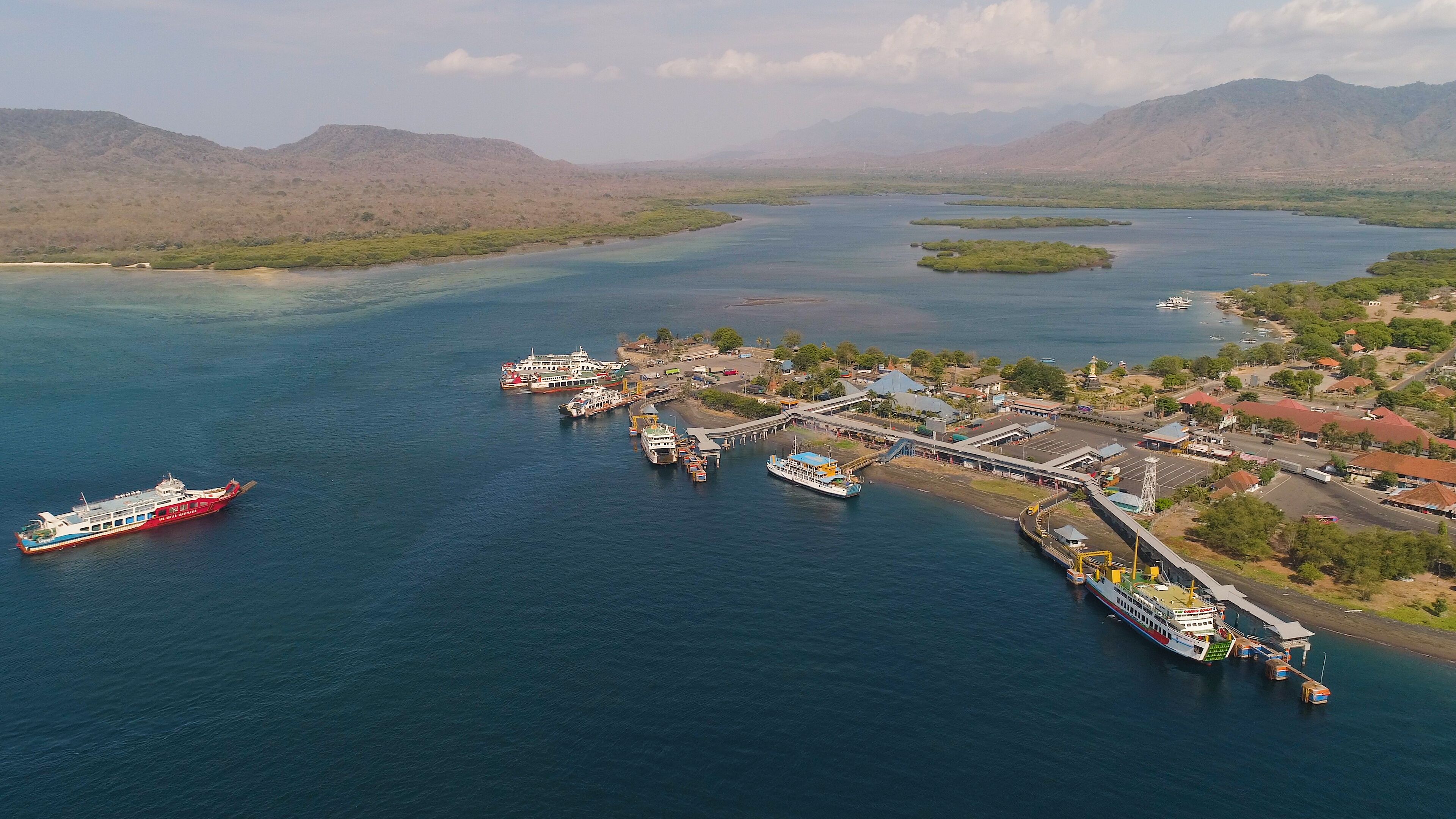 Aerial view ferry port gilimanuk with ferry boats, vehicles. Ferries transport vehicles and passengers in port. Port for departure from Bali to the island of Java.
