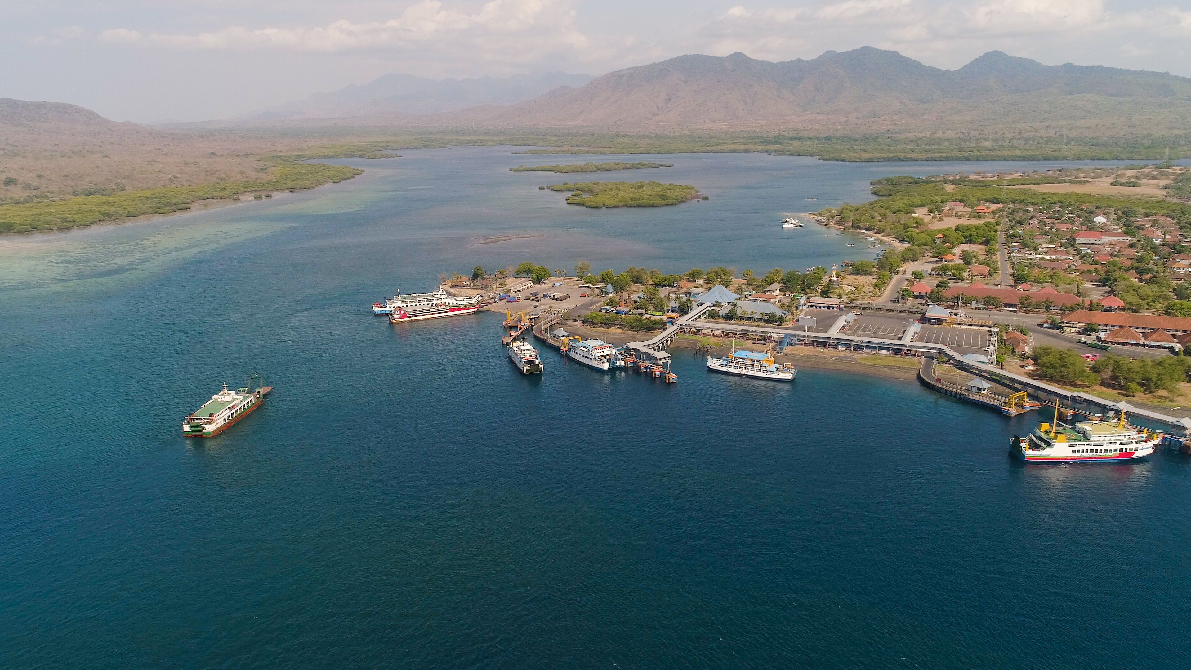 Aerial view ferry port gilimanuk with ferry boats, vehicles. Ferries transport vehicles and passengers in port. Port for departure from Bali to the island of Java.