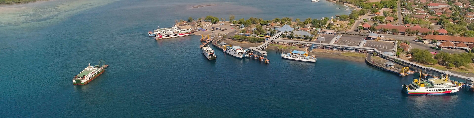 Aerial view ferry port gilimanuk with ferry boats, vehicles. Ferries transport vehicles and passengers in port. Port for departure from Bali to the island of Java.