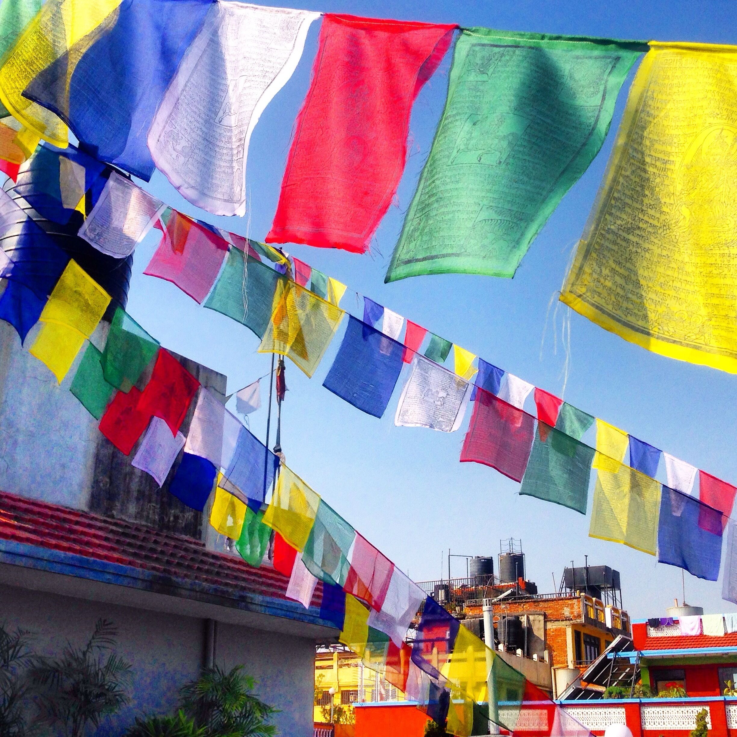 Colorful prayer flags strung across a building.