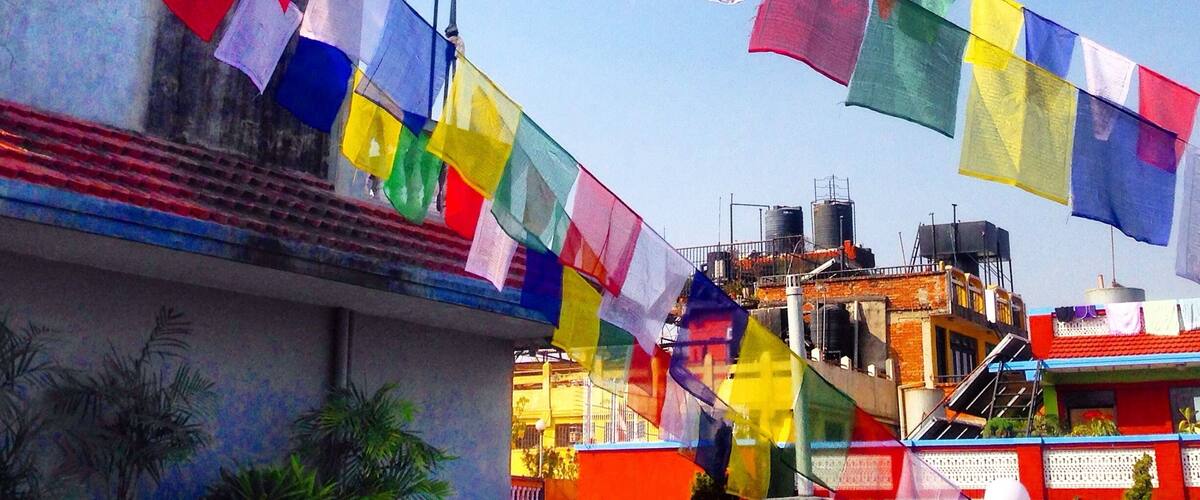 Colorful prayer flags strung across a building.