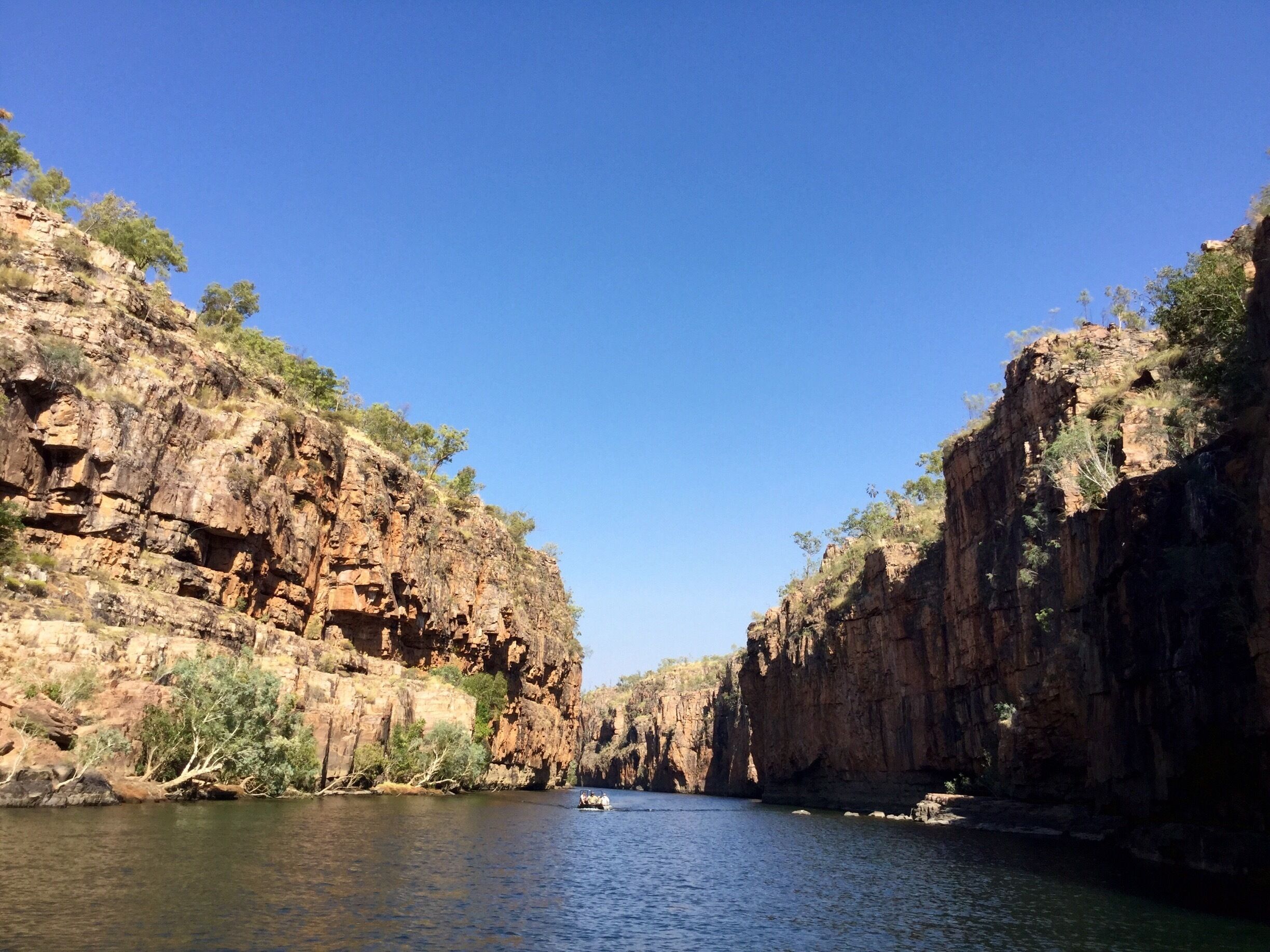 A canyon with steep rock walls and a river flowing through it.