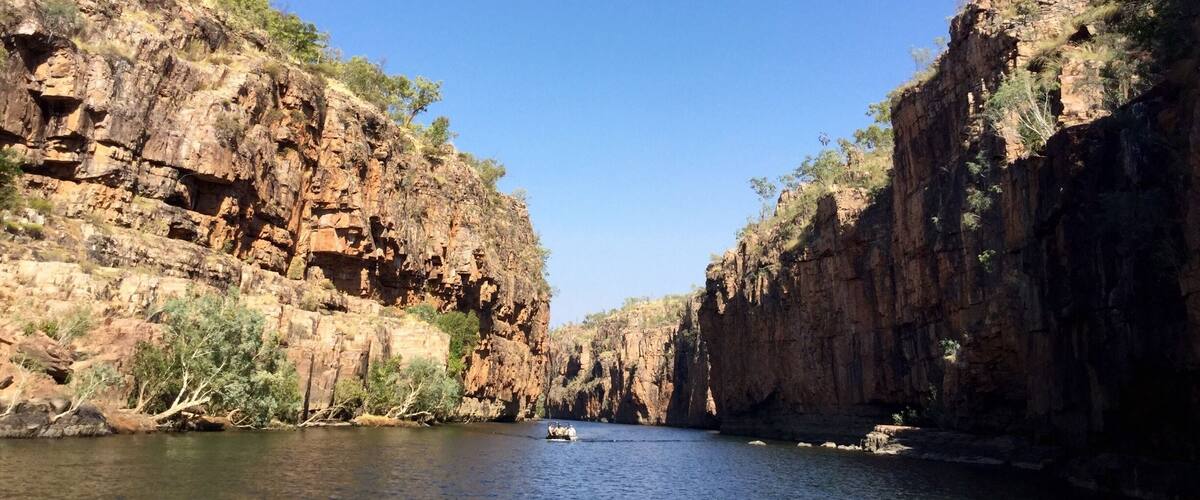 A canyon with steep rock walls and a river flowing through it.