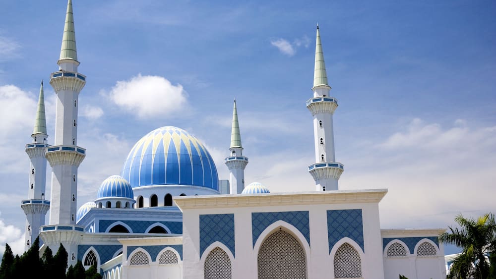 A mosque with blue domes and white minarets.