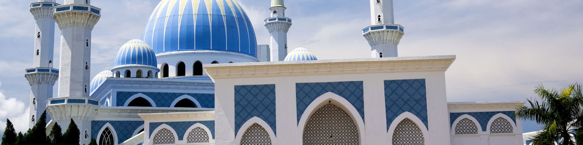 A mosque with blue domes and white minarets.