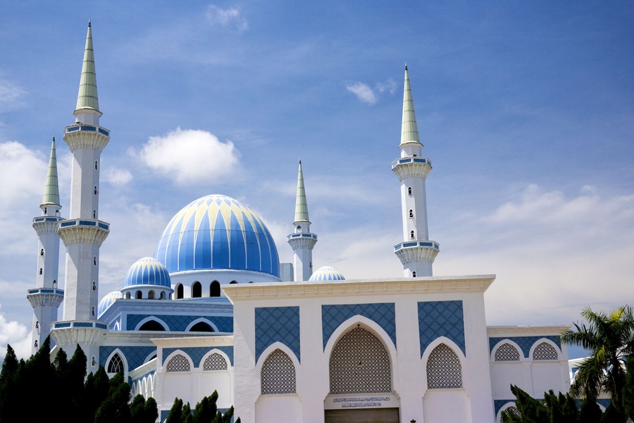 A mosque with blue domes and white minarets.