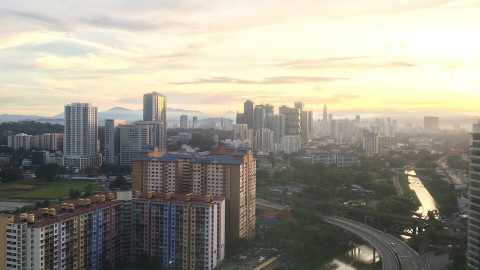 A cityscape with high-rise buildings, a river, and a bridge.