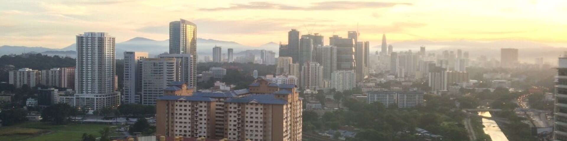 A cityscape with high-rise buildings, a river, and a bridge.