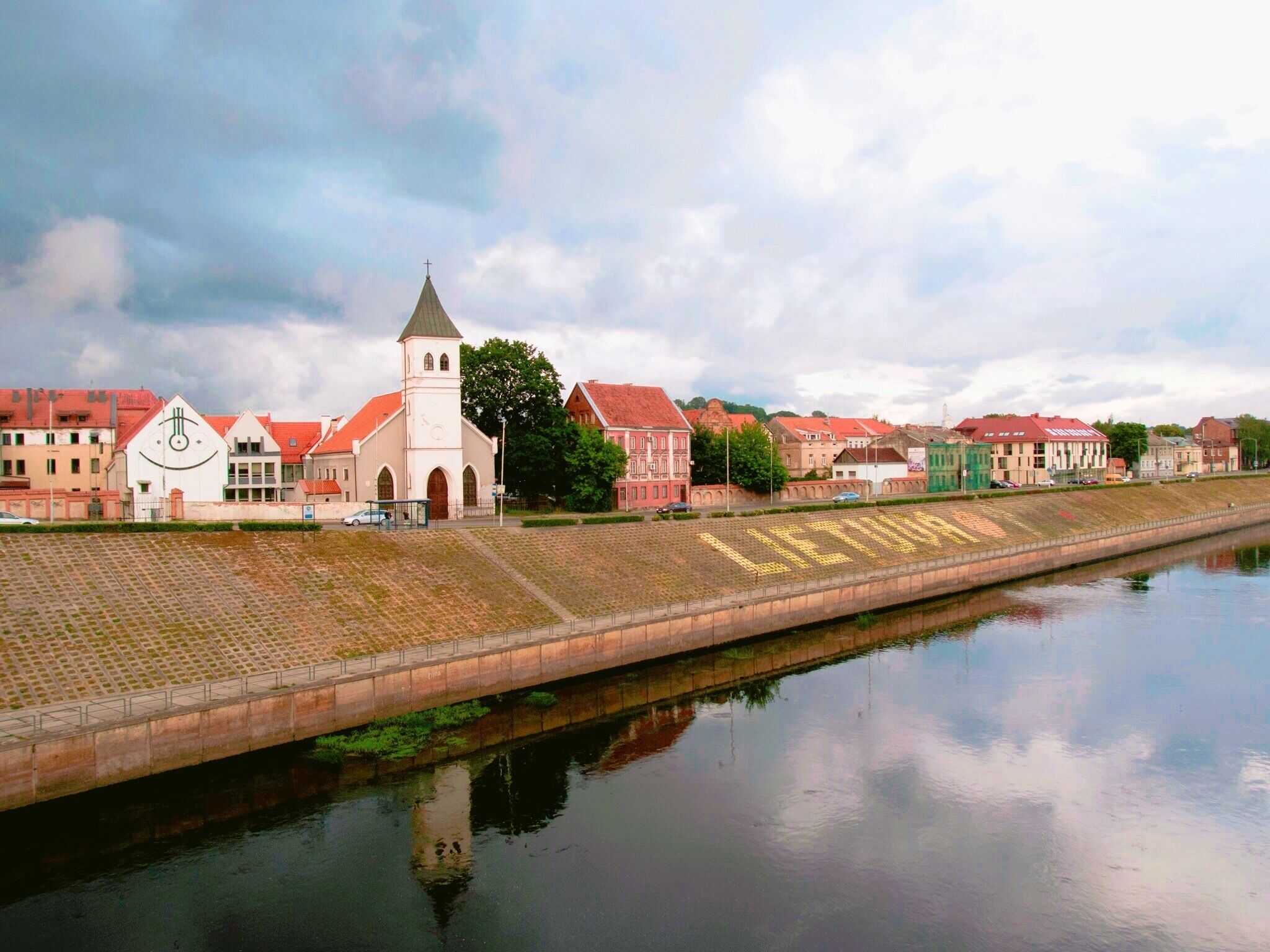 Un río con un puente, una iglesia y edificios históricos.