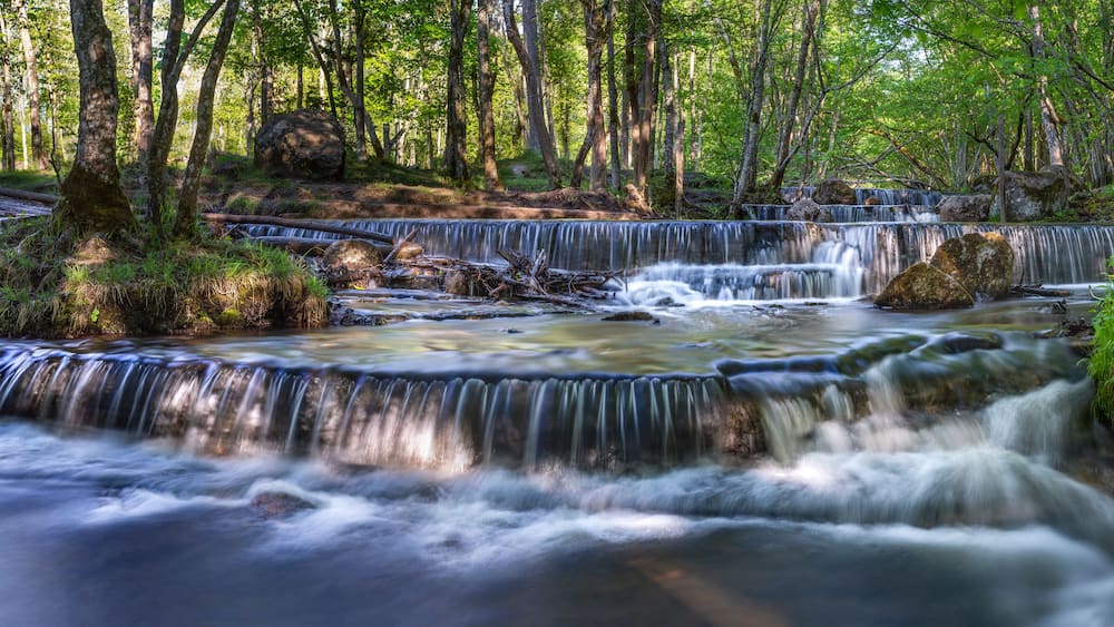 Silverfallet Nature reserve and staircase Waterfall in Lush forest and rural mill environment near town Skovde, Sweden