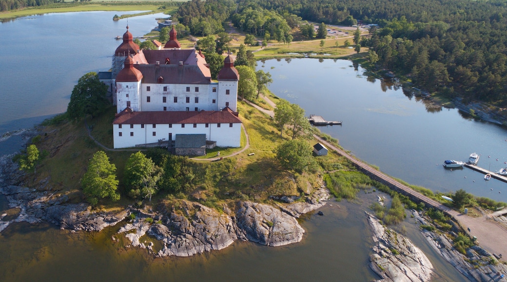 A large white building with red roofs on a small island surrounded by water.