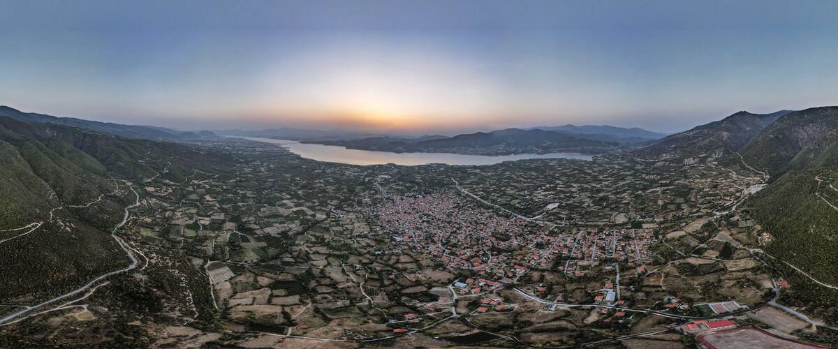 A mountainous landscape with a river and a town.