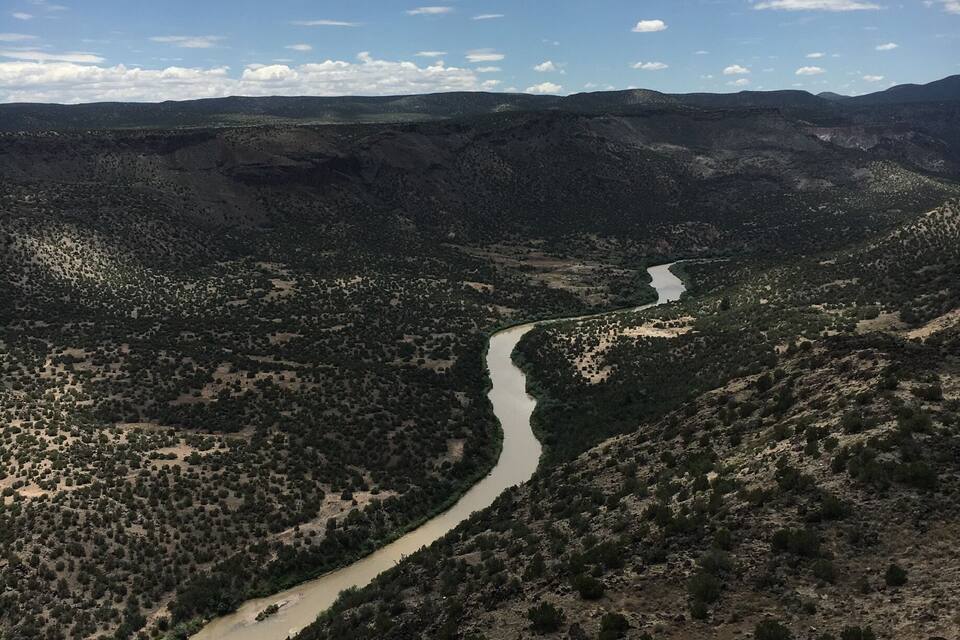 A river winding through a mountainous landscape with sparse vegetation.