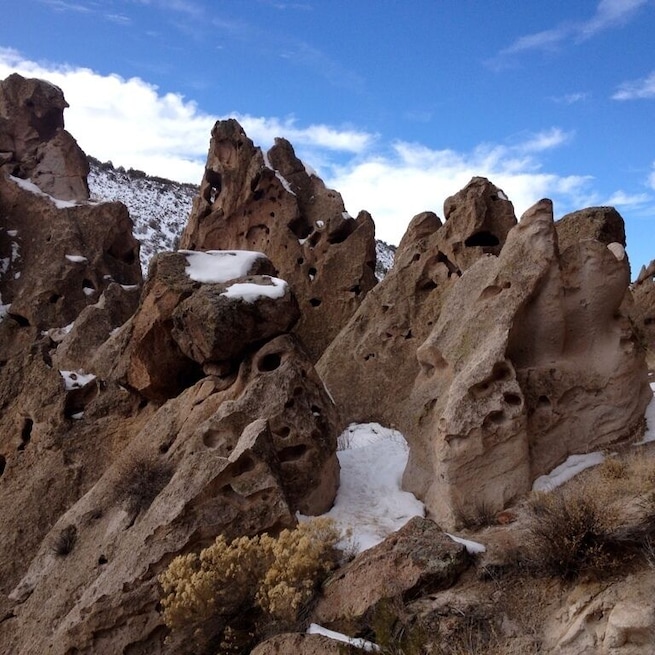 A rocky landscape with snow patches and holes in the rock formations.