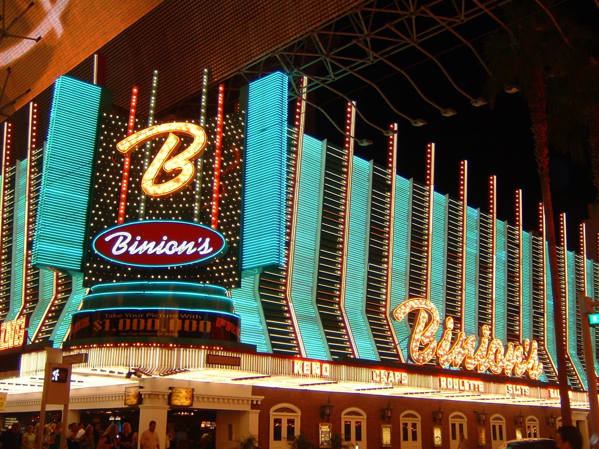 Un casino muy iluminado con letreros de neón que dicen "Bimini's" y "Bimini's Casino".