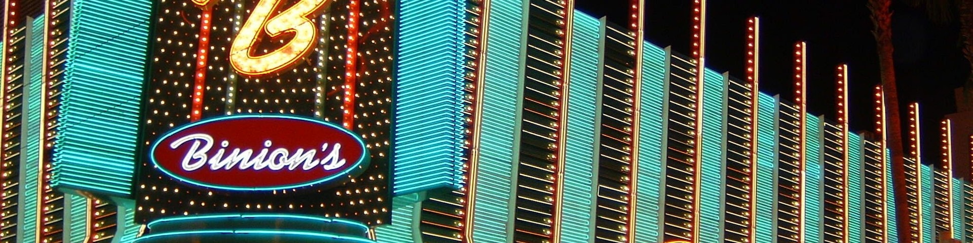 Un casino muy iluminado con letreros de neón que dicen "Bimini's" y "Bimini's Casino".