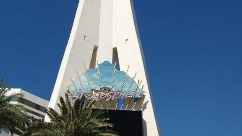 Une haute tour blanche, surmontée d’une plateforme d’observation en forme de sphère et d’une enseigne bleue et blanche portant l’inscription « SkyDome ».