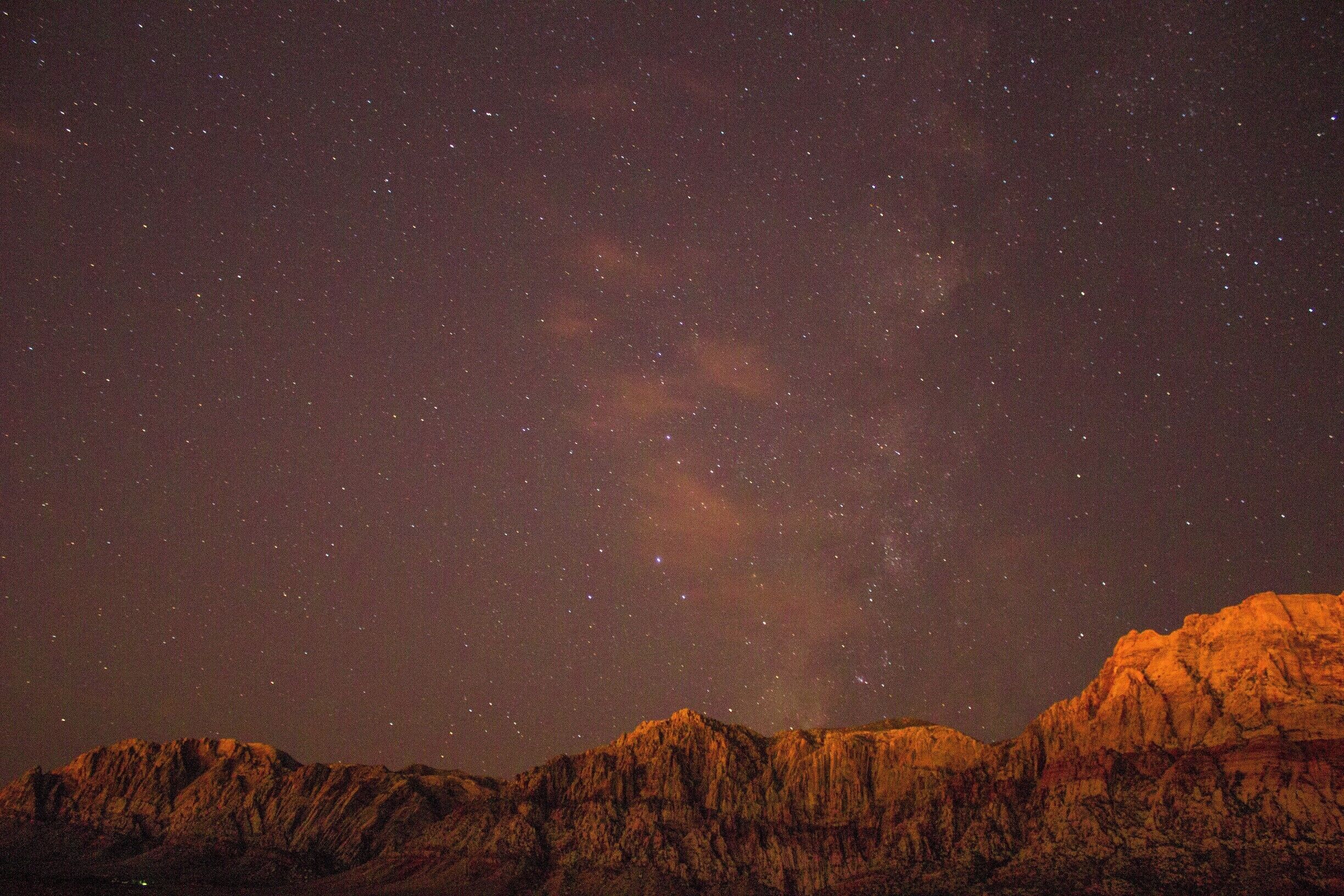Cielo estrellado sobre un paisaje montañoso.
