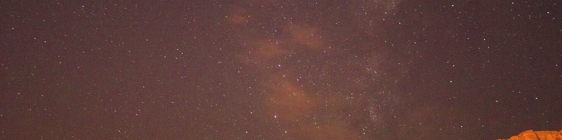 Cielo estrellado sobre un paisaje montañoso.