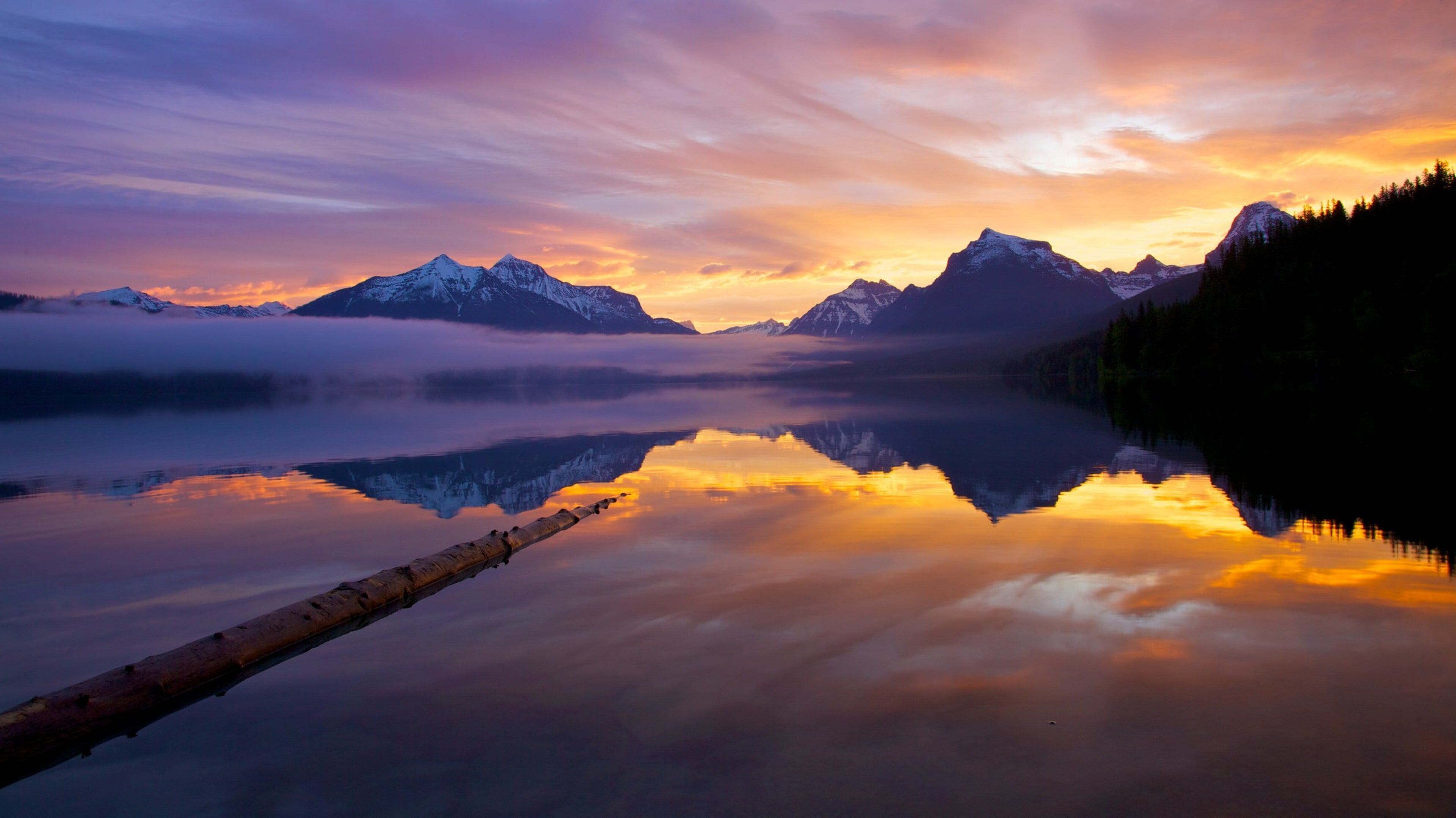 Glacier National Park featuring a sunset and a lake or waterhole