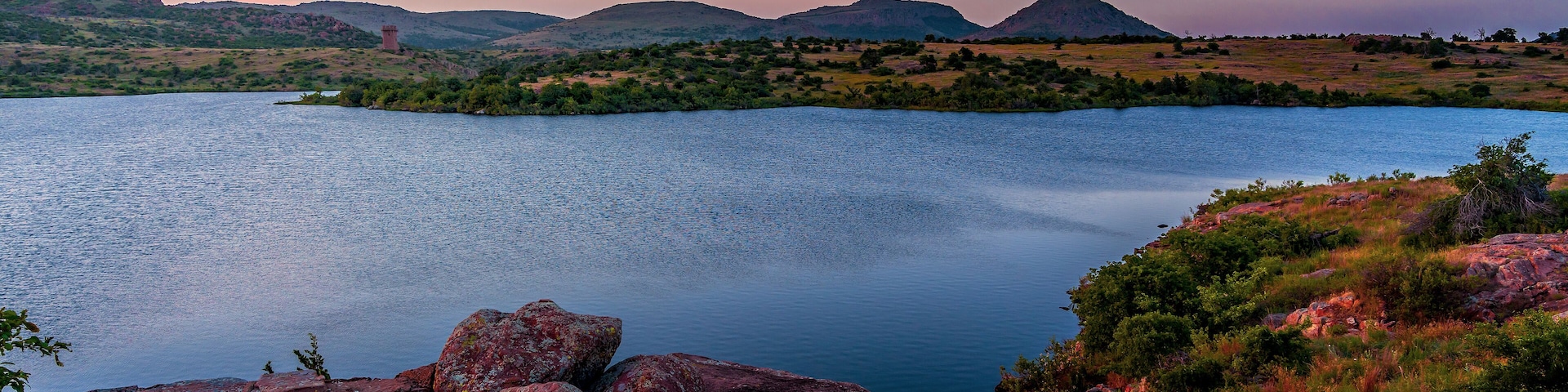 A lake surrounded by rocky terrain and distant mountains.
