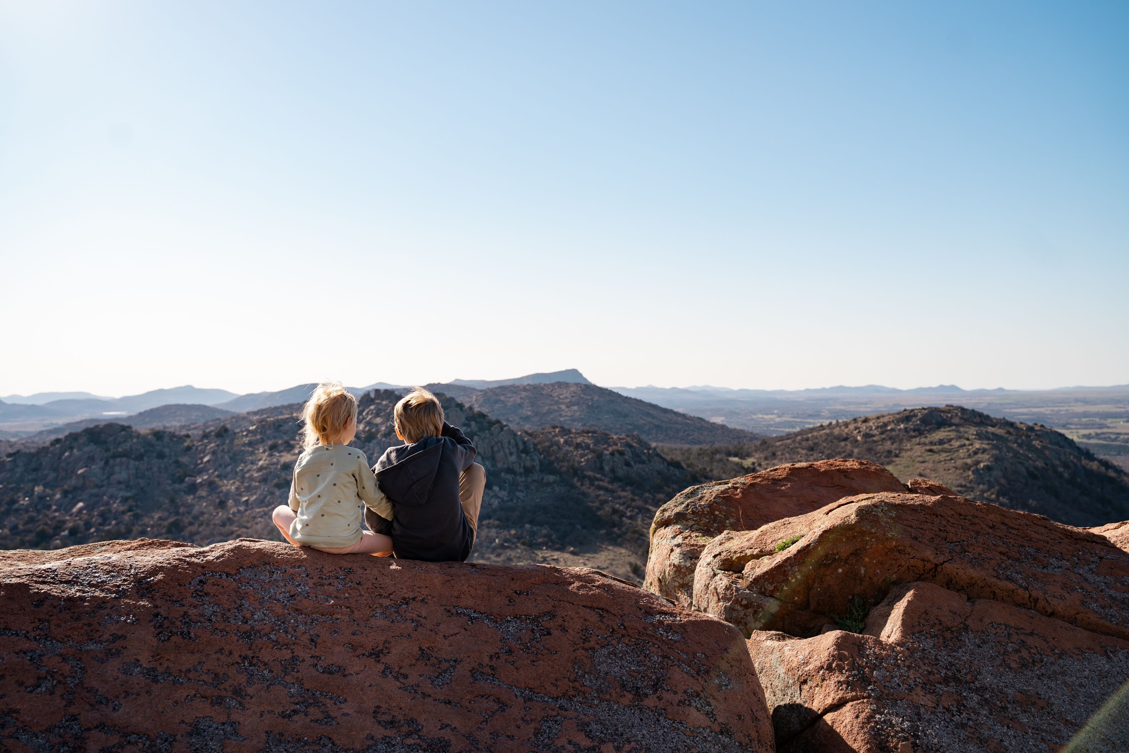 Children Sitting On Mountain Top In Wichita Mountain Wildlife Refuge