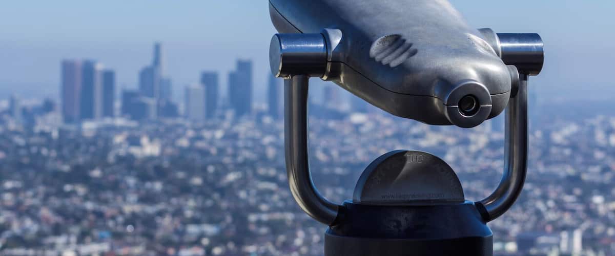 A telescope with a cityscape in the background.