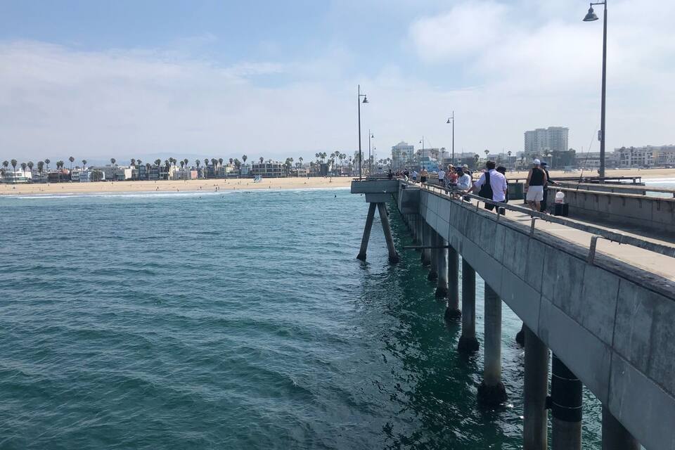 Un muelle que se adentra en el océano, con gente caminando a lo largo del mismo.