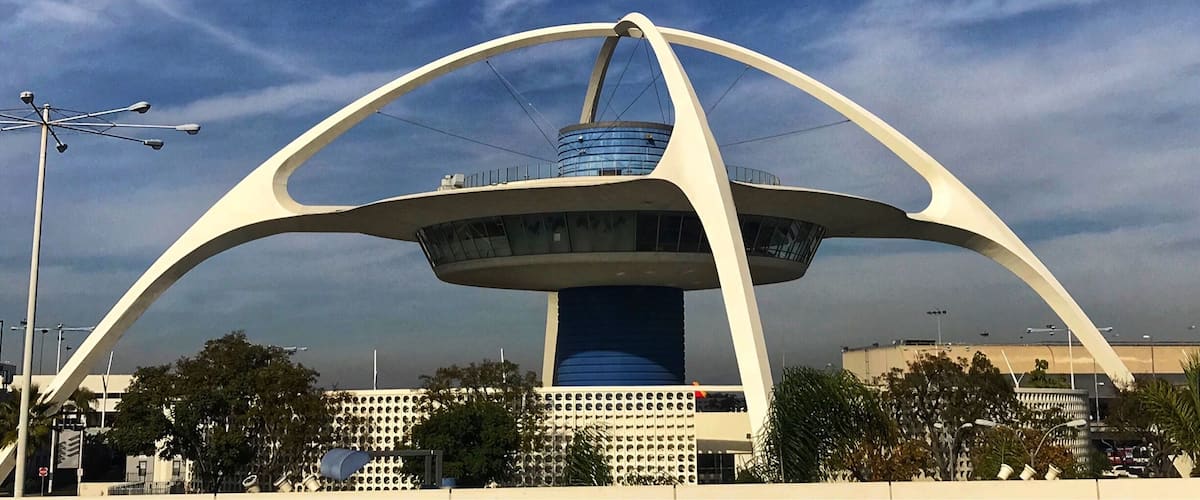 A modern architectural structure with a circular central tower and a distinctive arch design.