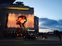 A large billboard with a target design and a woman's face, in front of a building with a 'Flemings' sign.