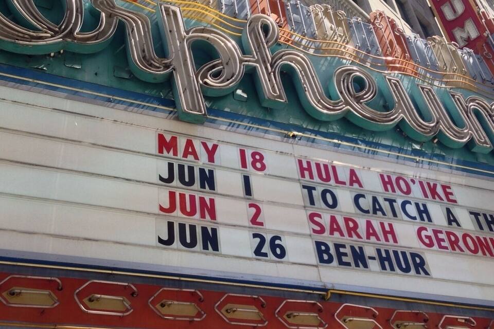 A marquee with the name "Orpheum" and a list of dates and events.