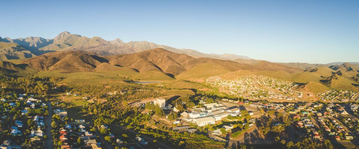 A town nestled between mountains with a clear sky.