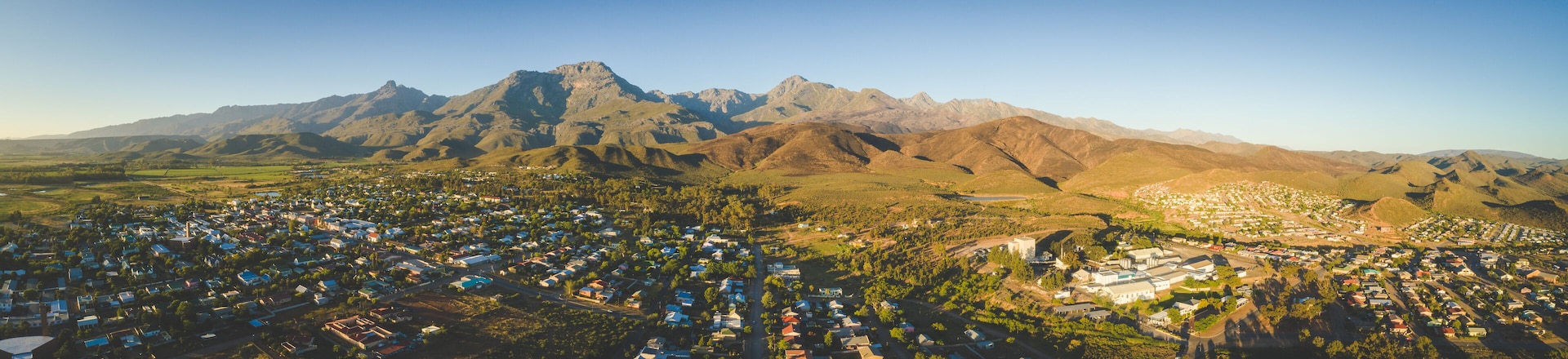 A town nestled between mountains with a clear sky.