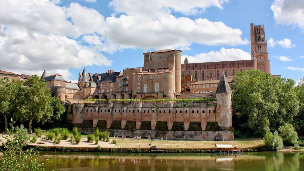 Un château historique, avec une rivière au premier plan et un ciel dégagé.