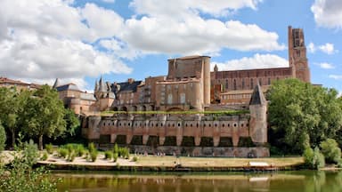 Un castillo histórico con un río al frente y cielo despejado.